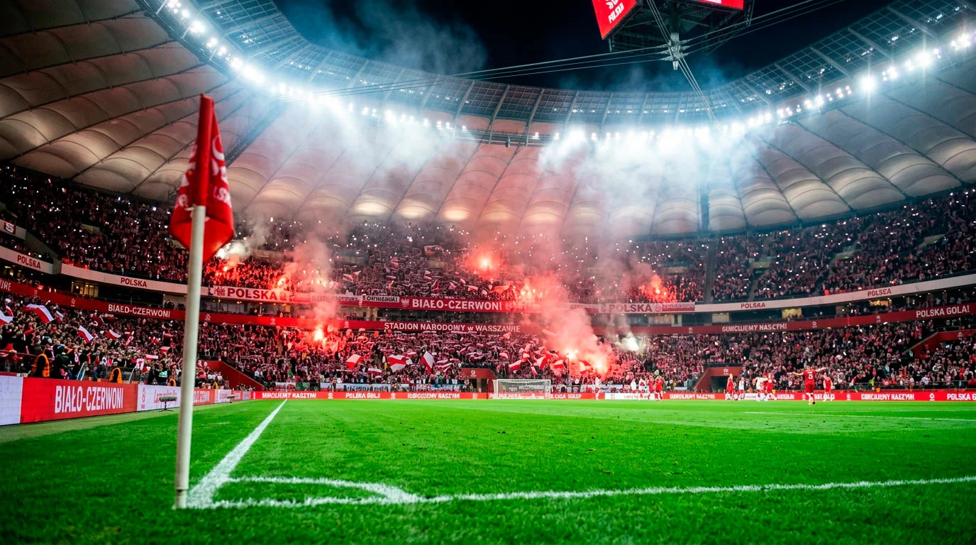 Piłkarze w białych strojach świętujący gola na stadionie narodowym podczas meczu kwalifikacyjnego